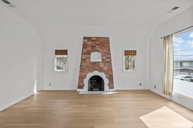 unfurnished living room with visible vents, a healthy amount of sunlight, and light wood-style flooring