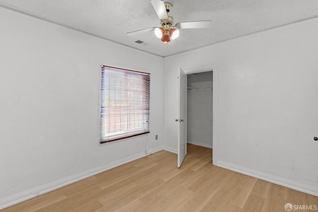 unfurnished bedroom with visible vents, baseboards, light wood-style flooring, ceiling fan, and a textured ceiling