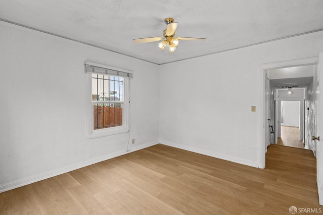 unfurnished room with light wood finished floors, a textured ceiling, baseboards, and ceiling fan