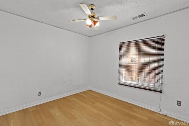 spare room featuring a ceiling fan, baseboards, visible vents, a textured ceiling, and light wood-type flooring