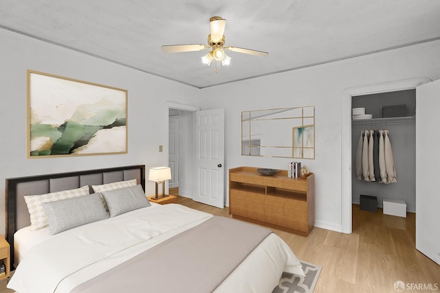 bedroom with ceiling fan, a closet, baseboards, and wood finished floors