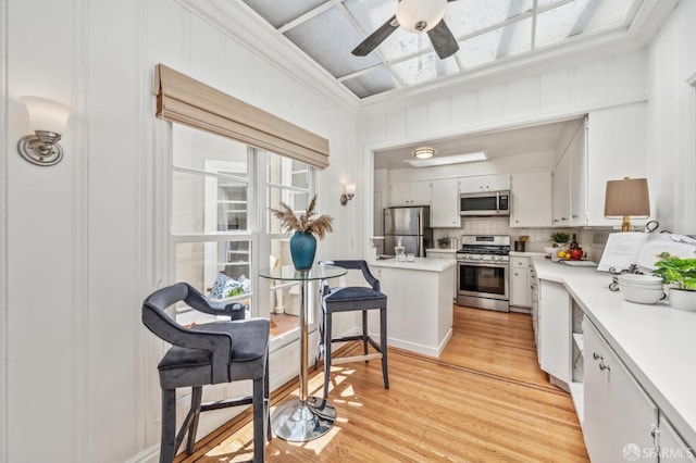 25 Roselyn Ter, San Francisco, CA 94118 - kitchen with appliances with stainless steel finishes, a ceiling fan, light countertops, light wood-style flooring, and backsplash