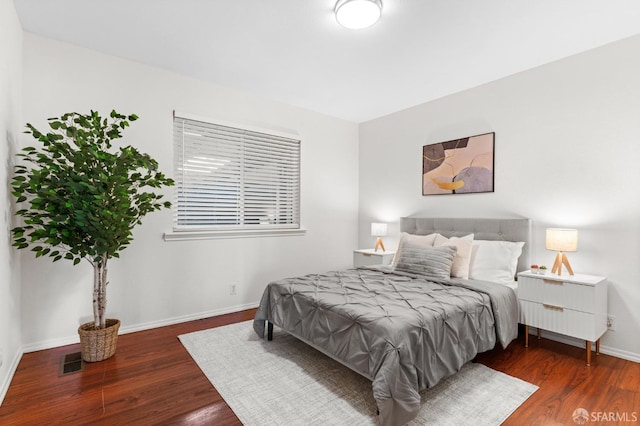 bedroom featuring wood finished floors, visible vents, and baseboards