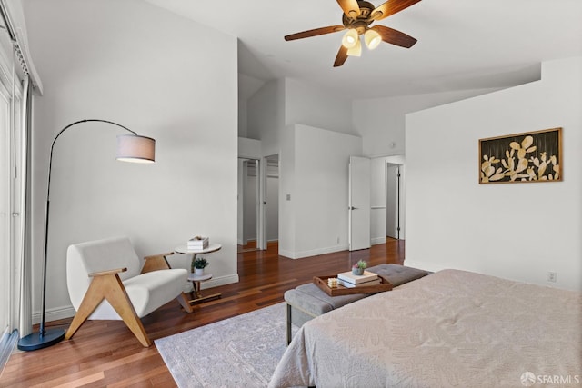 bedroom with ceiling fan, baseboards, wood finished floors, and vaulted ceiling