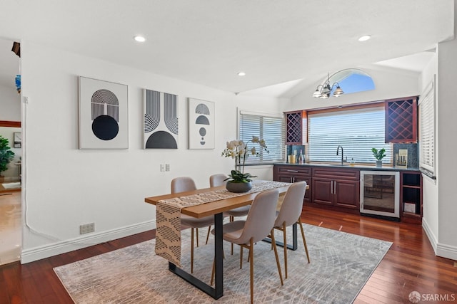 dining area featuring wine cooler, dark wood-style floors, indoor wet bar, and lofted ceiling