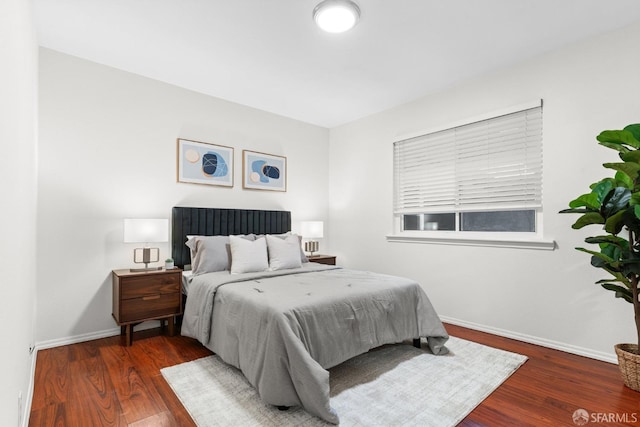 bedroom with baseboards and wood finished floors