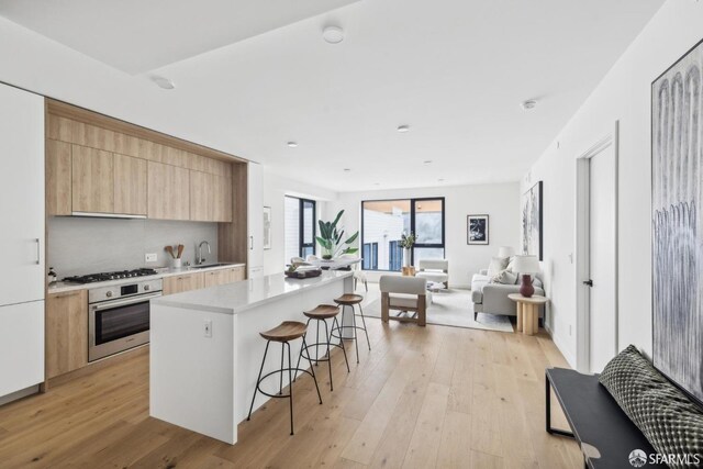 915 N Point St Unit J3, San Francisco, CA 94109 - kitchen with oven, a breakfast bar area, modern cabinets, open floor plan, and a kitchen island