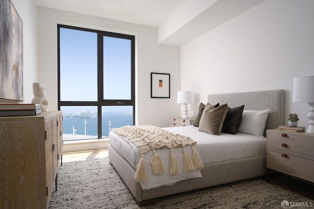 bedroom with a water view and multiple windows