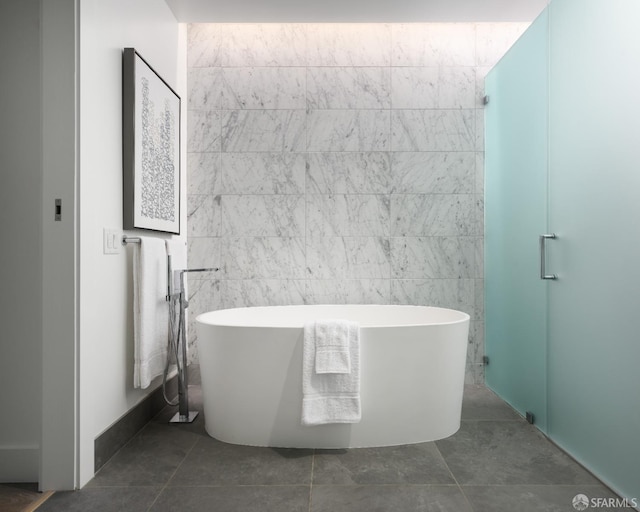 bathroom with separate shower and tub, tile patterned floors, and tile walls