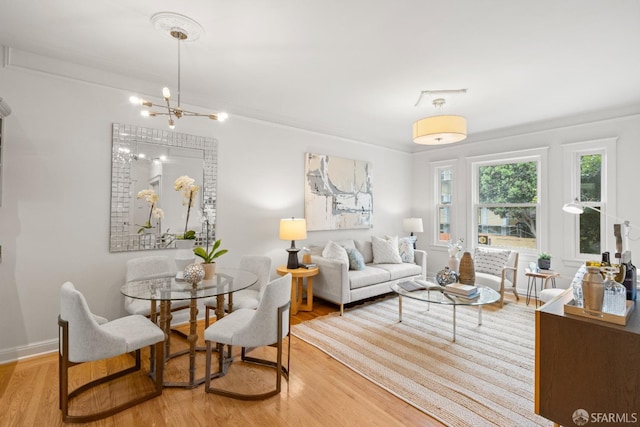 living area featuring wood finished floors, baseboards, and a chandelier