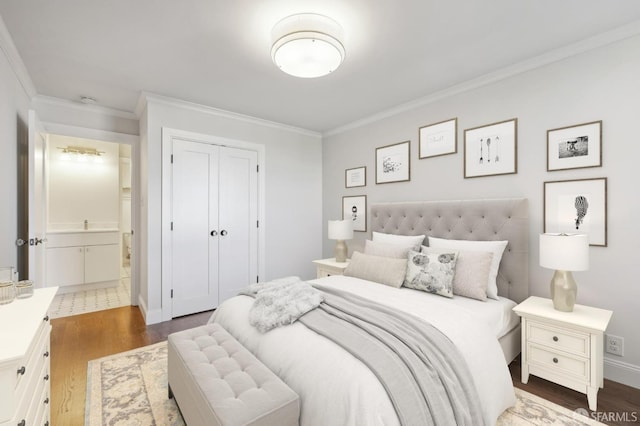 bedroom with connected bathroom, a closet, dark hardwood / wood-style floors, and crown molding