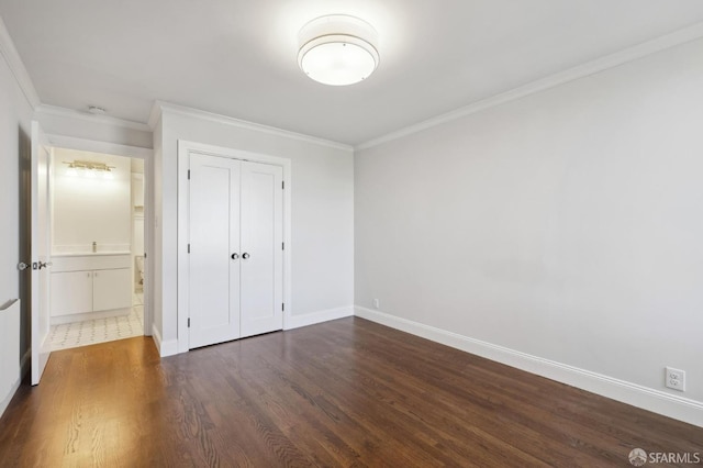 unfurnished bedroom featuring ornamental molding, dark hardwood / wood-style flooring, and a closet