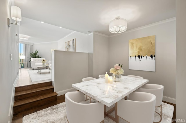 dining room featuring wood-type flooring, crown molding, and a chandelier