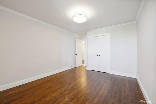 empty room featuring ornamental molding and dark hardwood / wood-style flooring