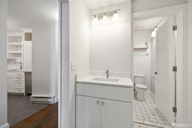 bathroom featuring a baseboard heating unit, hardwood / wood-style floors, vanity, and toilet