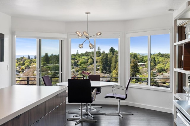 office area with dark wood-type flooring, baseboards, and a notable chandelier