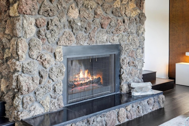 details with a lit fireplace and wood finished floors