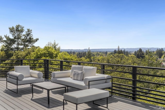 wooden terrace with a forest view and outdoor lounge area