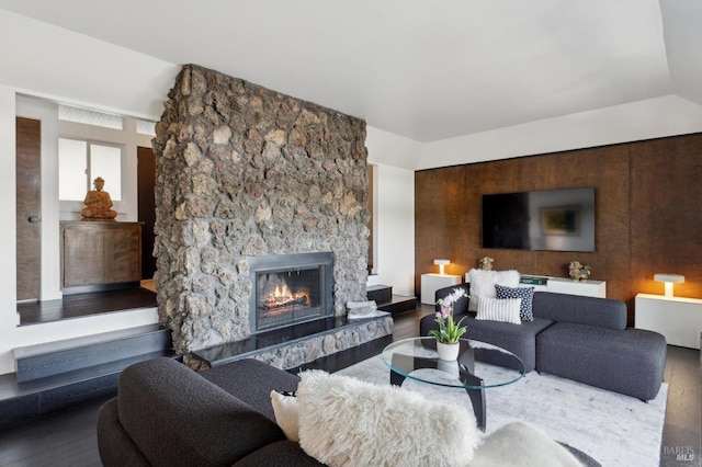 living area with a stone fireplace and hardwood / wood-style floors