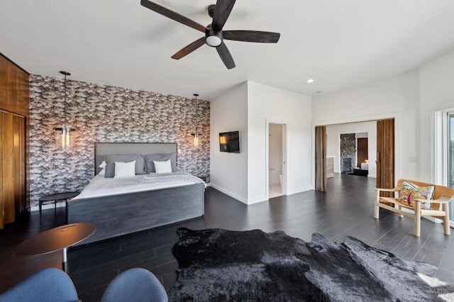 bedroom featuring ceiling fan, baseboards, and wood finished floors