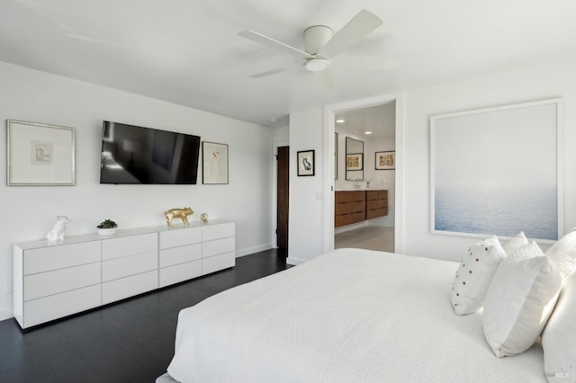 bedroom with dark wood-type flooring, baseboards, ensuite bath, and a ceiling fan