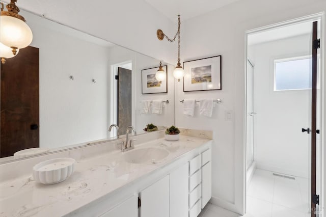 bathroom featuring tile patterned flooring, vanity, and a stall shower