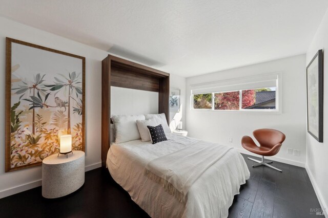 bedroom featuring dark wood-style floors and baseboards