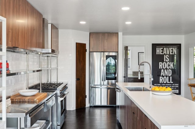kitchen featuring brown cabinets, a sink, modern cabinets, and stainless steel appliances
