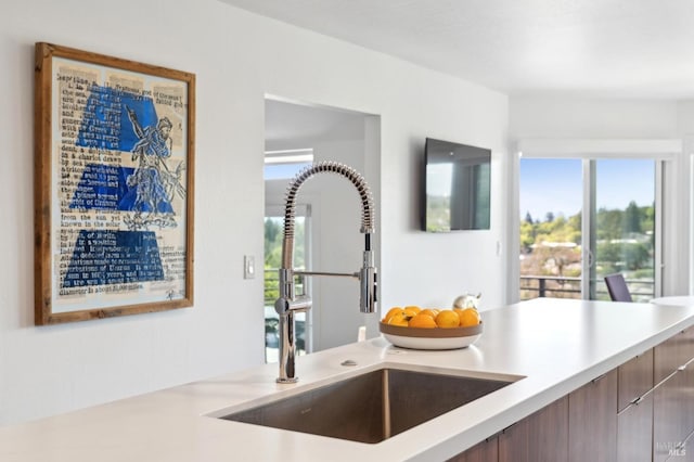 kitchen featuring modern cabinets, light countertops, and a sink