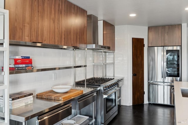kitchen with stainless steel appliances, modern cabinets, wall chimney exhaust hood, and brown cabinetry