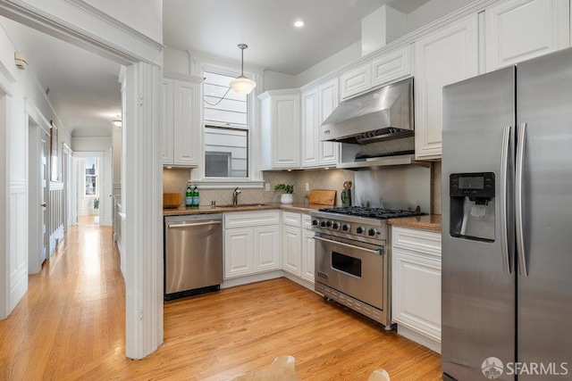 813 Union St, San Francisco, CA 94133 - kitchen with appliances with stainless steel finishes, exhaust hood, light wood-style flooring, white cabinets, and backsplash