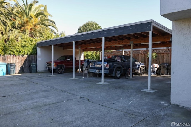 view of vehicle parking featuring a carport and fence