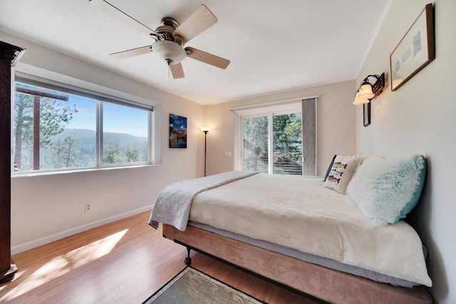 bedroom with wood finished floors, a ceiling fan, and baseboards