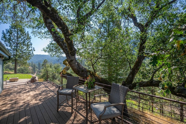 wooden terrace with a fire pit and a mountain view