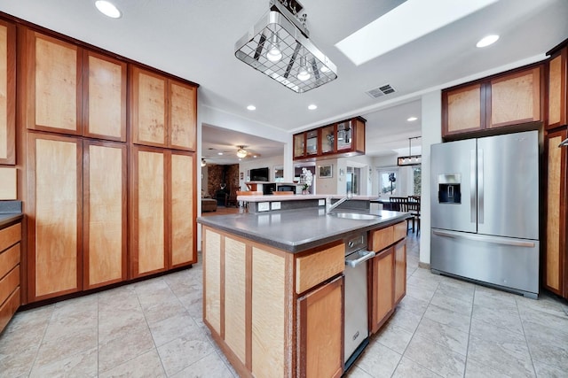 kitchen with dark countertops, a sink, stainless steel fridge with ice dispenser, visible vents, and recessed lighting