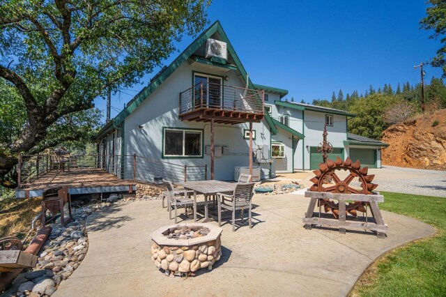 back of house featuring a patio area, an outdoor fire pit, a balcony, and outdoor dining space