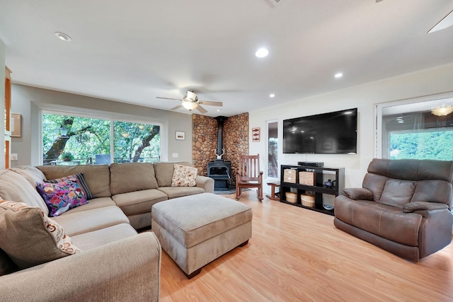 living area with recessed lighting, light wood-style flooring, a wood stove, and ceiling fan