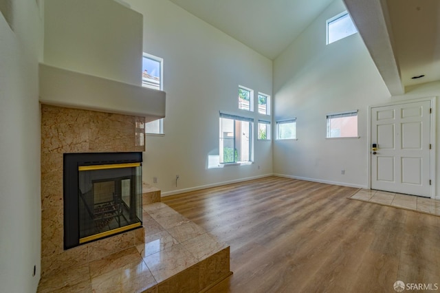 981 Asilomar Ter Unit 1, Sunnyvale, CA 94086 - unfurnished living room featuring high vaulted ceiling, wood finished floors, and a tiled fireplace