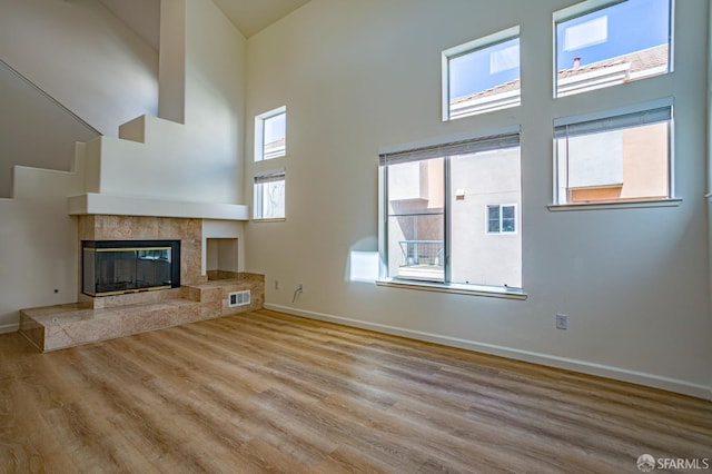 981 Asilomar Ter Unit 1, Sunnyvale, CA 94086 - unfurnished living room featuring a high ceiling, wood finished floors, and a high end fireplace