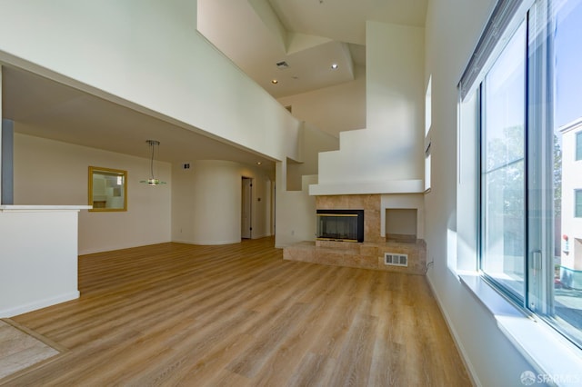 981 Asilomar Ter Unit 1, Sunnyvale, CA 94086 - unfurnished living room with healthy amount of natural light, light wood finished floors, a high ceiling, a tiled fireplace, and recessed lighting