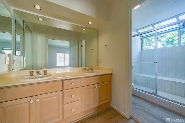 981 Asilomar Ter Unit 1, Sunnyvale, CA 94086 - bathroom featuring wood finished floors, double vanity, a stall shower, and recessed lighting