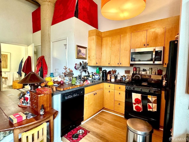 1 Federal St Unit 46, San Francisco, CA 94107 - kitchen with a sink, dark countertops, black appliances, and light wood-type flooring
