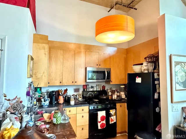 1 Federal St Unit 46, San Francisco, CA 94107 - kitchen with dark countertops, black appliances, a sink, and light brown cabinets
