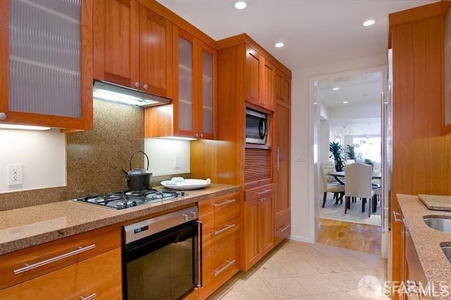 2040 Broadway St Unit 102, San Francisco, CA 94115 - kitchen with appliances with stainless steel finishes, brown cabinetry, light stone counters, and recessed lighting