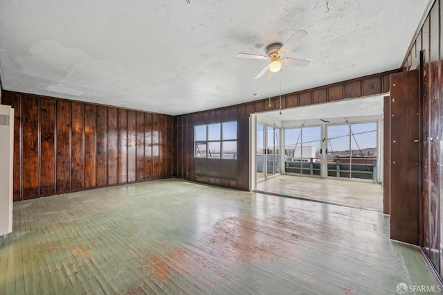 80 Bronte St, San Francisco, CA 94110 - spare room with hardwood / wood-style flooring, a textured ceiling, a ceiling fan, and wood walls