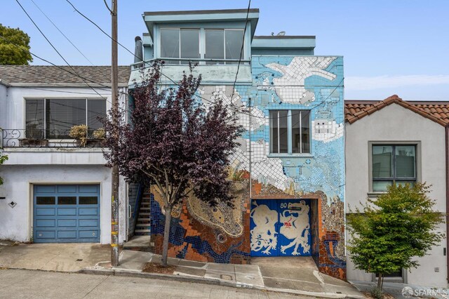 80 Bronte St, San Francisco, CA 94110 - view of front facade featuring an attached garage, stucco siding, and concrete driveway