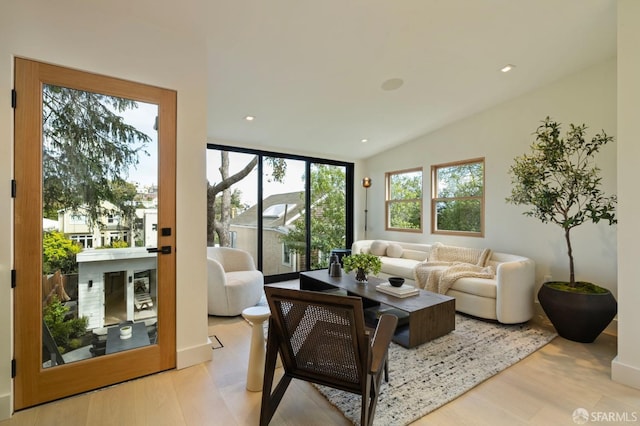 living area with recessed lighting, lofted ceiling, and wood finished floors