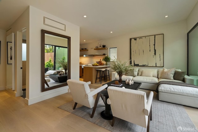 living room featuring recessed lighting, baseboards, and light wood-style flooring