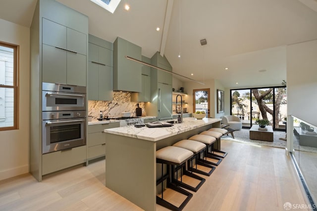 kitchen with backsplash, light wood-style floors, modern cabinets, and double oven