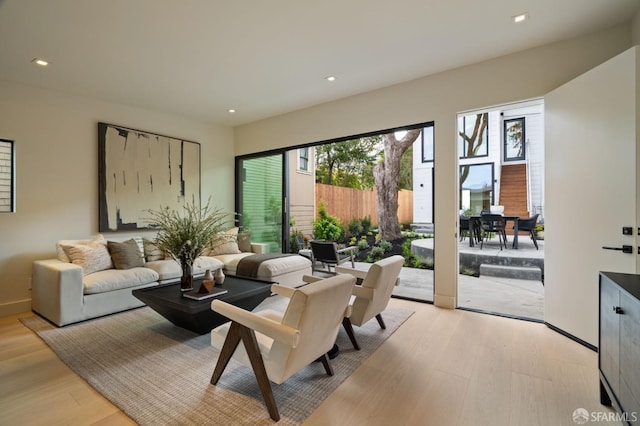 living area with recessed lighting, baseboards, and light wood finished floors
